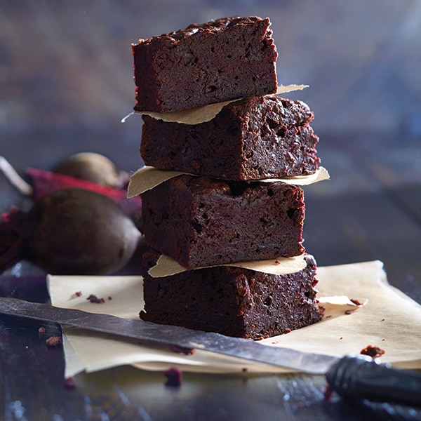 brownies na pečicím papíru s nožem a řepou v pozadí